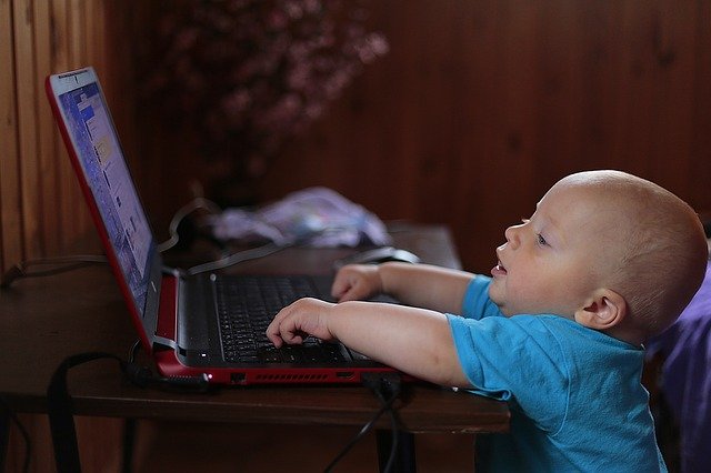 Infant playing with laptop
